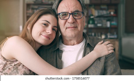 Cute young daughter embracing her father with love
