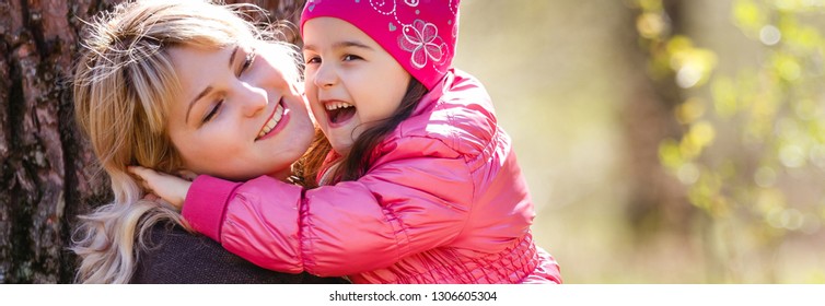 Cute young daughter piggy back ride and her mother 
