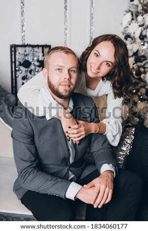 Cute young family husband and wife at the Christmas tree. Happy new year concept. Toning.