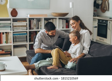 Cute Young Family Using Tablet Together At Home