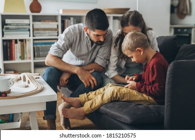 Cute Young Family Using Tablet Together At Home