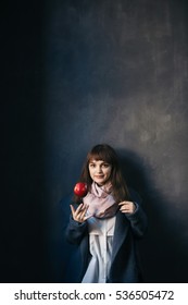 cute young girl on a dark background with apple