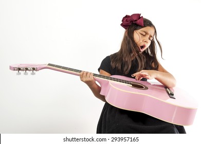 Cute young girl playing guitar and sing .