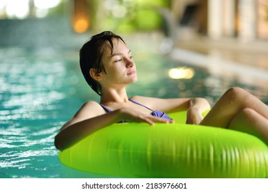 Cute Young Girl Playing With Inflatable Ring In Indoor Pool. Child Learning To Swim. Kid Having Fun With Water Toys. Family Fun In A Pool. Activities For Family With Kids.