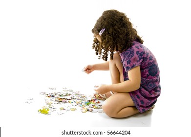cute young girl playing with puzzle .