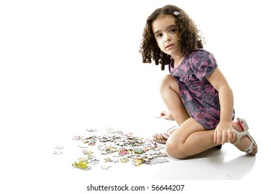 cute young girl playing with puzzle .