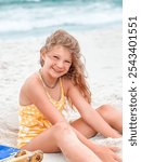 Cute young girl plays in the sand on the beach at the ocean 