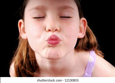 Cute young girl puckering up for a kiss
