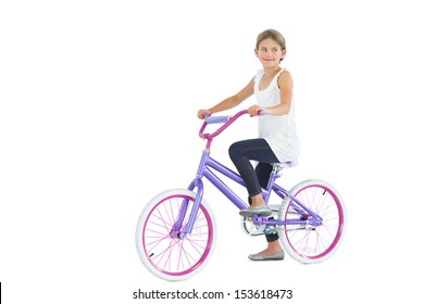 Cute Young Girl Riding Bike While Posing On White Background