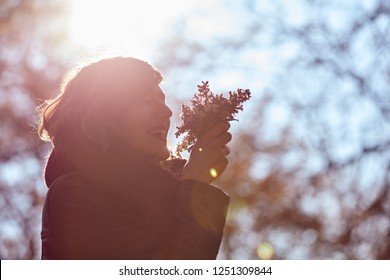 Cute Young Girl Smelling Nice Bouquet Of Flowers In Nature.
