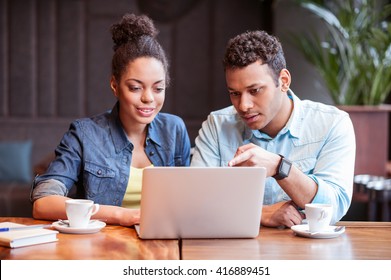 Cute young guy and girl using notebook