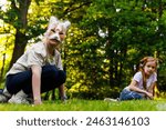 Cute young little kid girl wear cat furry mask enjoy have fun playing outdoors in forest street park. Children therian wild animal character trendy fan culture. Teenager social expression hobby