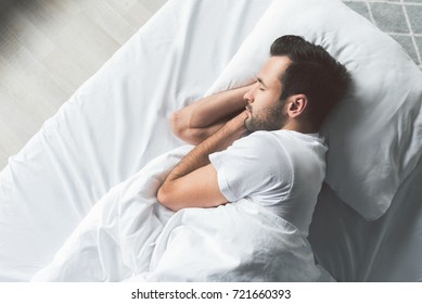 Cute young man sleeping on bed - Powered by Shutterstock