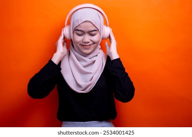 Cute young muslim woman enjoying music with headphone on. Enjoying music concept - Powered by Shutterstock