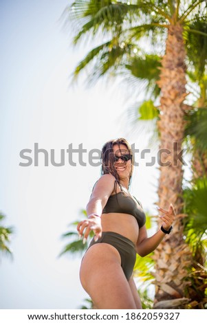 Similar – Brunette surfer woman with top and bikini holding surfboard