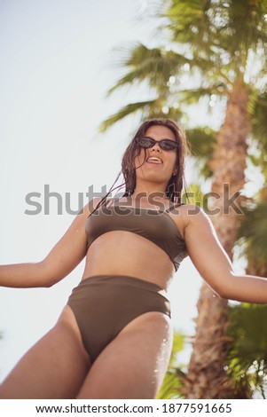 Similar – Brunette surfer woman in bikini standing with surfboard