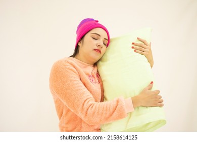 Cute Young White Asian Woman Wearing Pink Pajamas And A Night Cap, Lying On Her Side On A Pillow With Her Eyes Closed, On White Background