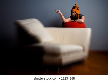 Cute Young Woman Calling You On The Sofa. Lounge And Relaxation Concept. Zoom Blur Effect