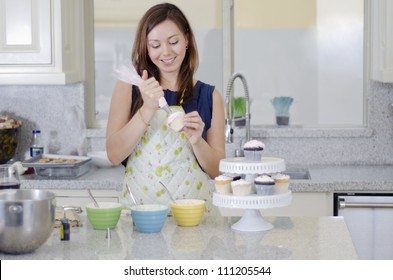 Cute Young Woman Decorating Cupcakes