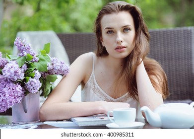 Cute young woman drinking coffee and resting in the garden - Powered by Shutterstock