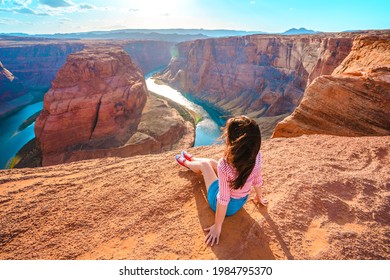 Cute young woman enjoying a view of Horseshoe Bend, Colorado River in Page, Arizona.