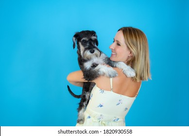 Cute Young Woman Hugs Her Puppy Schnauzer Dog. Love Between Owner And Dog. Isolated On White Background. Studio Portrait.