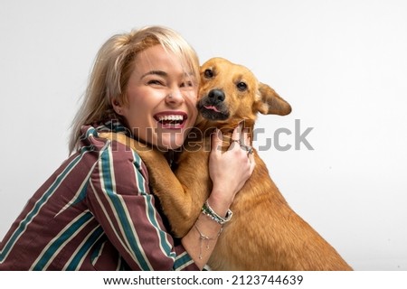 A cute young woman kisses and hugs her mongrel dog. Love between owner and dog. Isolated on white background. Studio portrait. Girl huging new lovely member of family. Pet care and animals concept Сток-фото © 