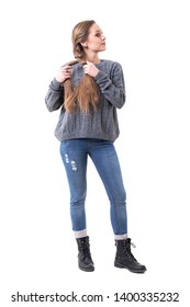 Cute Young Woman In Knitted Jumper Creating Hair Braids Looking Away At Mirror. Full Body Isolated On White Background. 