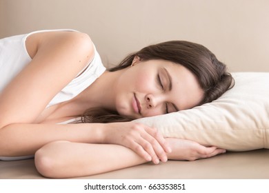 Cute Young Woman Sleeping On Side On Soft Pillow On Sofa, Lying Relaxed With Closed Eyes. Tired Beautiful Lady Resting At Home, Enjoying Pleasant Leisure. Daytime Drowsiness And Nap Concept. Close Up