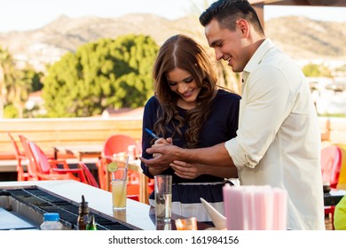 Cute Young Woman Writing Her Phone Number In A Man's Hand And Smiling