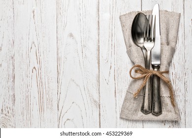 Cutlery Is In A Napkin Wrapped On An Old Table