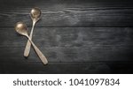 Cutlery: silver spoons on dark boards with copy space. Close-up.