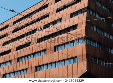 The cutoff view on the part of the modern  office building  with  rusted metallic panels on the facade walls