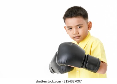 Cutout portrait of healthy little Asian boy on yellow shirt wearing black boxing gloves, confidently standing and ready to fight with high intension and strong effort to win sport or game competition