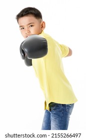 Cutout portrait of healthy little Asian boy on yellow shirt wearing black boxing gloves, confidently standing and ready to fight with high intension and strong effort to win sport or game competition