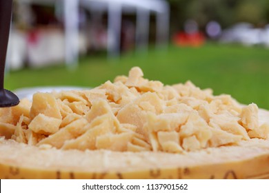 Cutted Parmesan Cheese Into Wheel Of Cheese. Close Up. Outdoor.