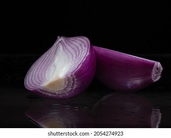 Cutted Ripe Red Onion On Glassy Surface And Black Background  