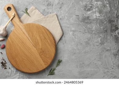 Cutting board, garlic, spices and rosemary on grey textured table, flat lay. Space for text - Powered by Shutterstock