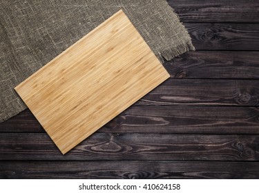 Cutting Board On A Dark Wooden Table. Top View