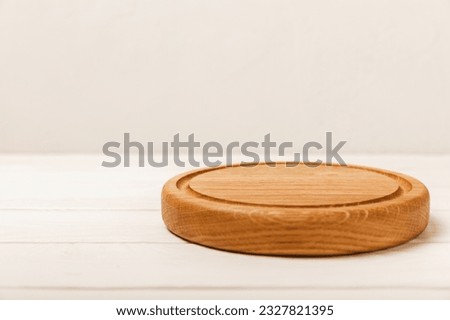 Cutting board on a white table. Pizza board.Kitchen wooden cutting board. Kitchenware. Menu. Recipe. The concept of cooking. Mockup