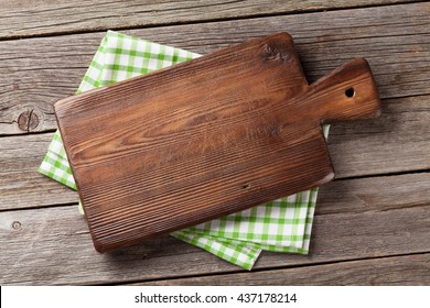 Cutting board over towel on wooden kitchen table. Top view - Shutterstock ID 437178214