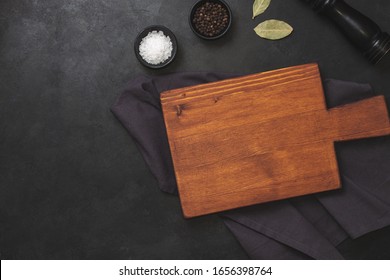 Cutting Board, Rosemary And Spices On Dark Table. Empty Wooden Chopping Board. Top View, Flatlay