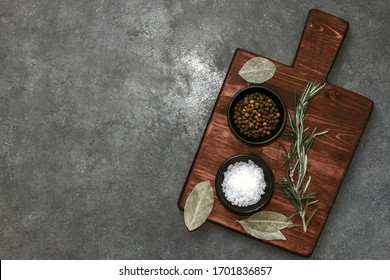 Cutting Board, Rosemary And Spices On Dark Table. Empty Wooden Chopping Board. Top View, Flatlay