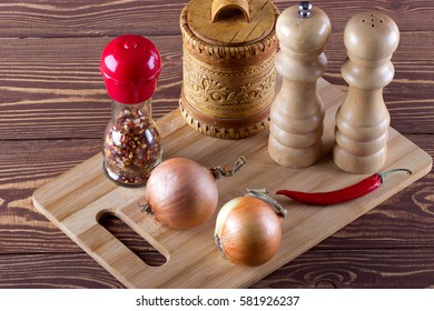 Cutting board with spice,onion,red pepper for cooking on rustic background.
