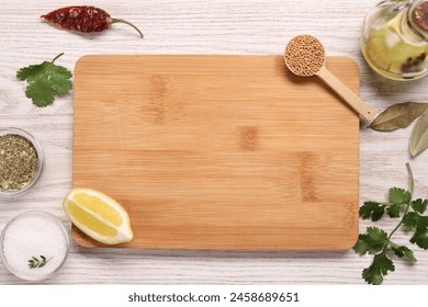 Cutting board, spices, oil and lemon on light wooden table, flat lay. Space for text - Powered by Shutterstock