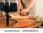 Cutting carrots for cooking tutorial - healthy food preparation, recording with smartphone, kitchen setup, vegetable slicing, culinary video, fresh produce, home cooking.