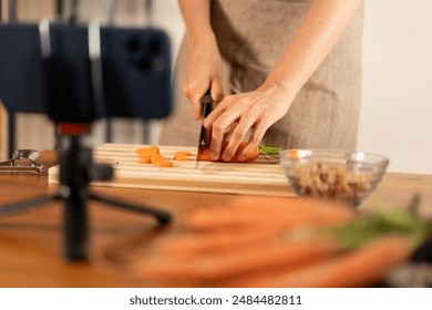 Cutting carrots for cooking tutorial - healthy food preparation, recording with smartphone, kitchen setup, vegetable slicing, culinary video, fresh produce, home cooking. - Powered by Shutterstock