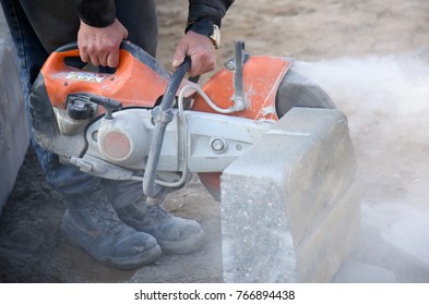 Cutting a concrete block with a circular saw on construction site