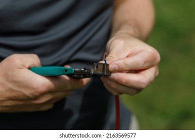 Cutting Electrical Wires With A Wire Cutter, Held In A Mans Hands
