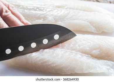 Cutting fish on white cutting board
